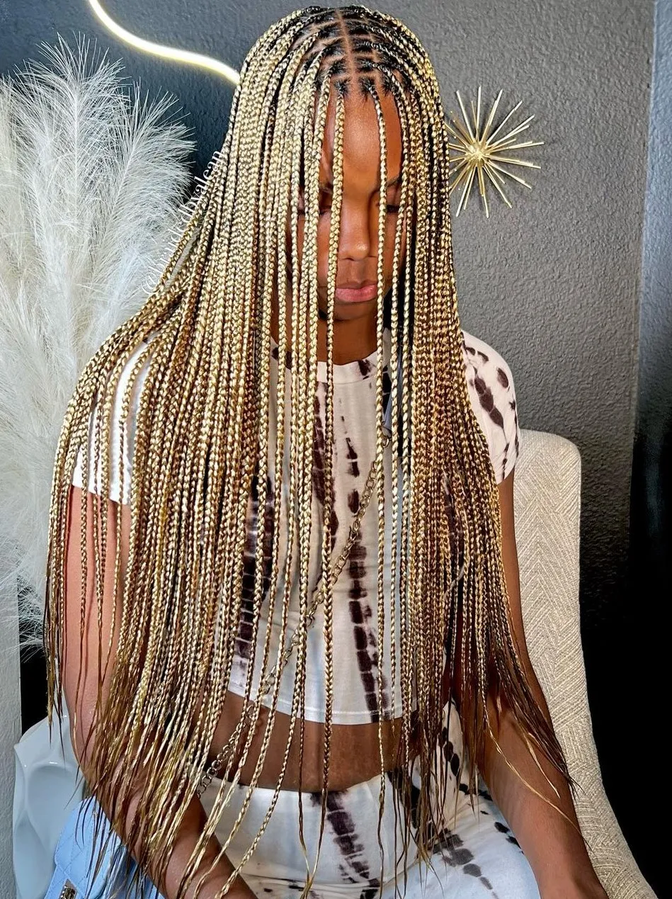 Long blonde and brown braids cascading down with feathery decor