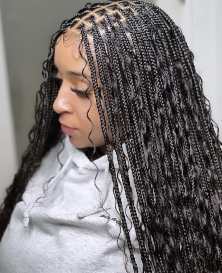 Intricate braided hairstyle with long, curly edges on a person in white